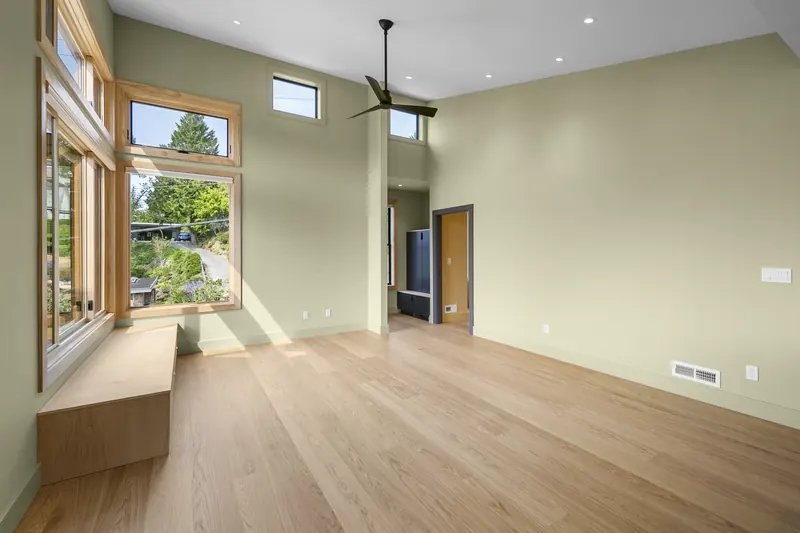 Living area with a vaulted ceiling and wood-framed windows